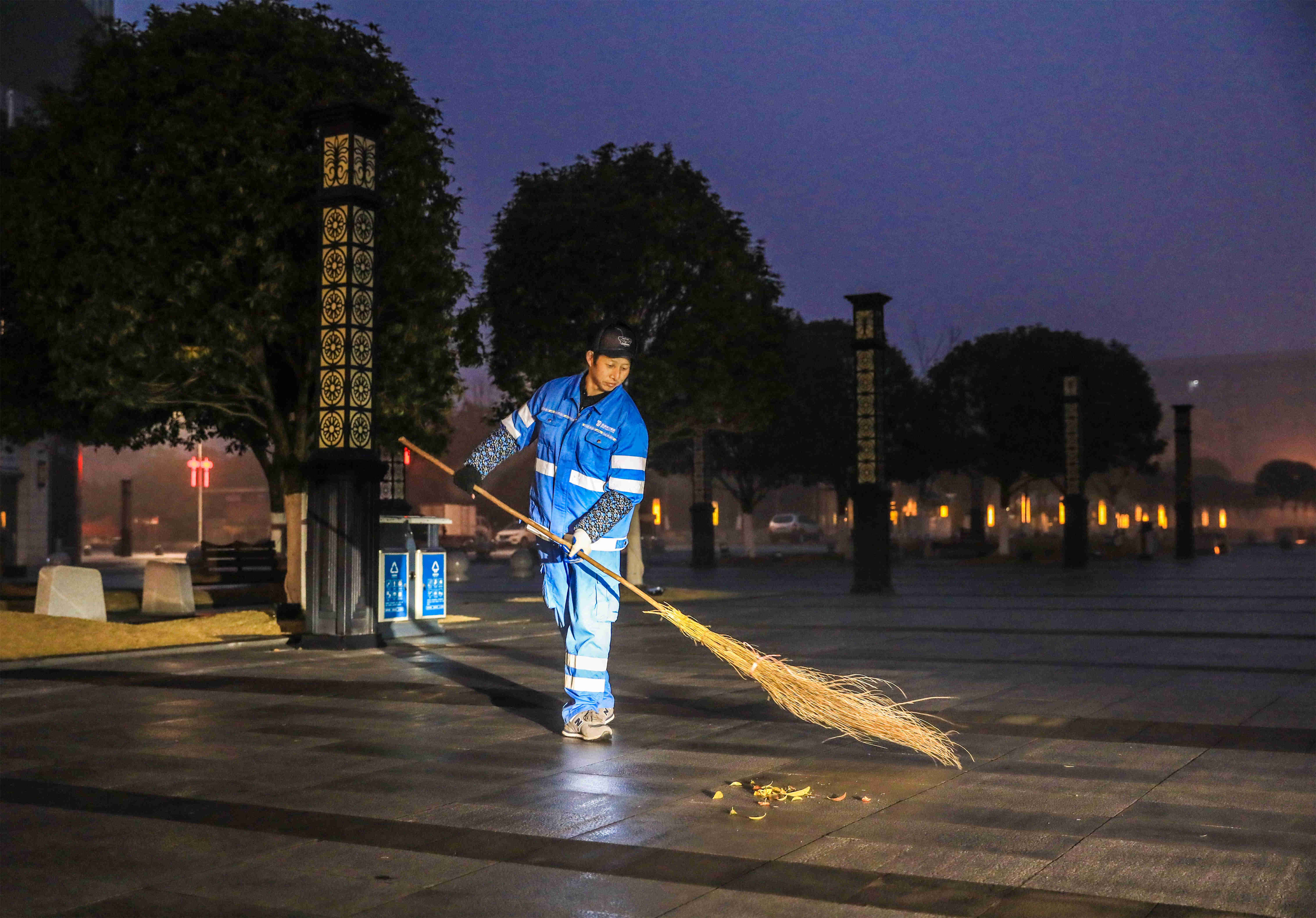 清晨,清洁工张兴中在都梁广场清扫街道(摄影:熊伟)